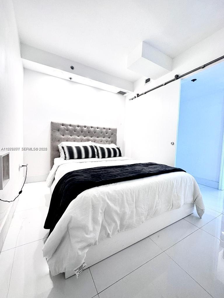 100 Lincoln Road, Unit 1404 Miami Beach, FL 33139 - Photo 6 of 18 a view of a bedroom with a bed and a window