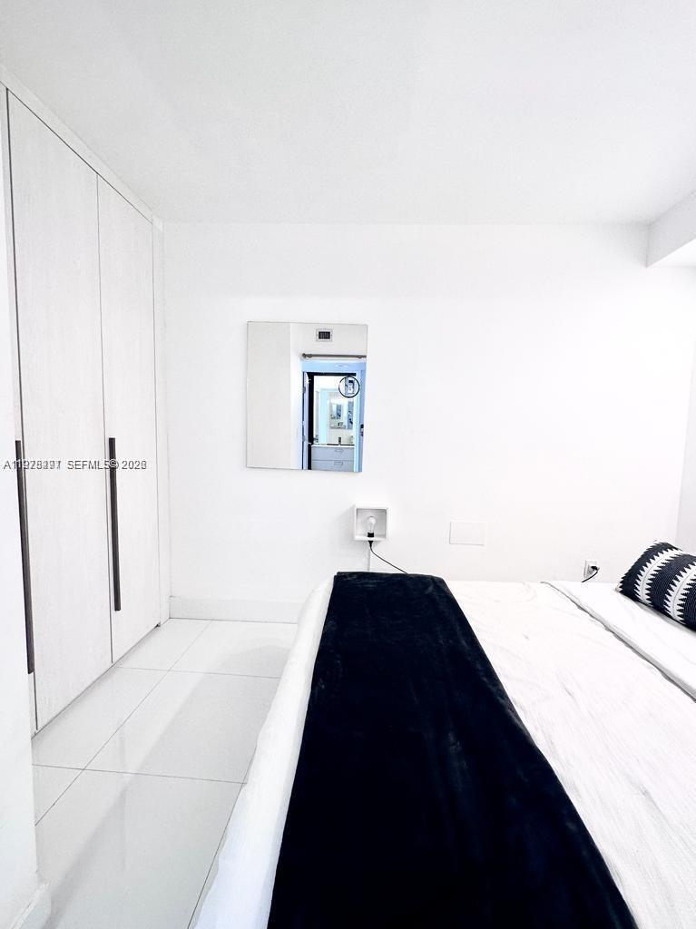 100 Lincoln Road, Unit 1404 Miami Beach, FL 33139 - Photo 8 of 18 a bedroom with a bed and a cabinets