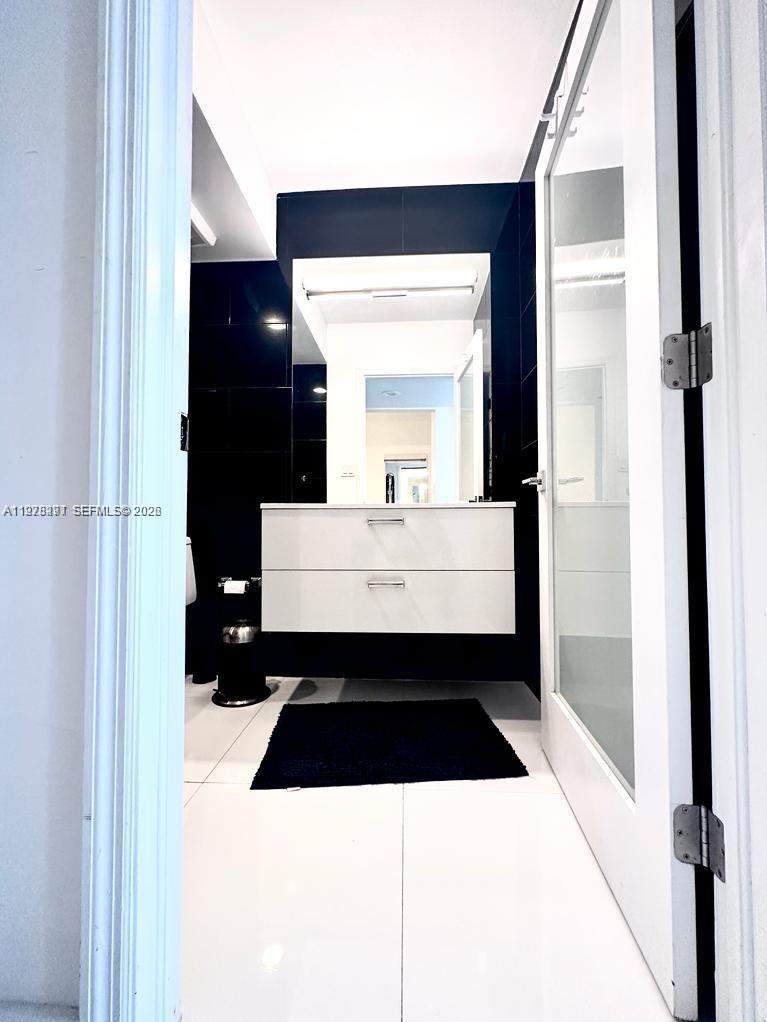 100 Lincoln Road, Unit 1404 Miami Beach, FL 33139 - Photo 9 of 18 a bathroom with a sink and a mirror
