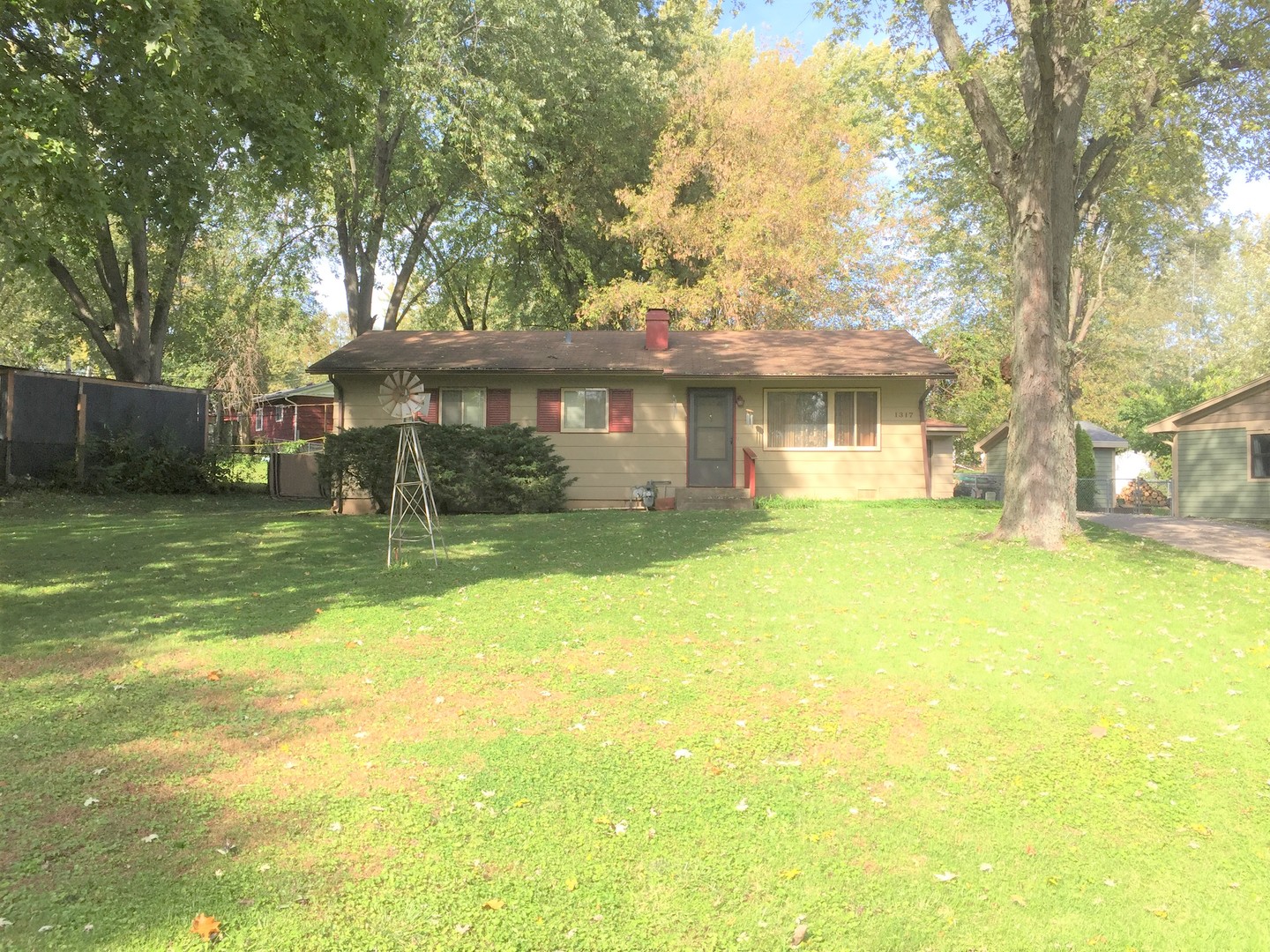a view of a house with a yard and a large tree
