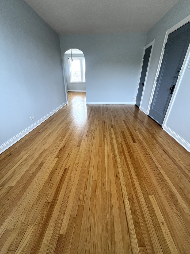 5852 West Higgins Avenue, Unit 3B Chicago, IL 60630 - Photo 3 of 9 a view of empty room with wooden floor