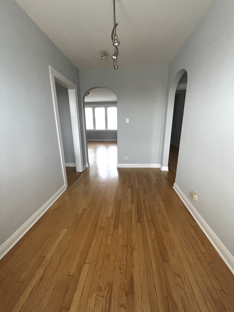 5852 West Higgins Avenue, Unit 3B Chicago, IL 60630 - Photo 7 of 9 a view of empty room with wooden floor and fan
