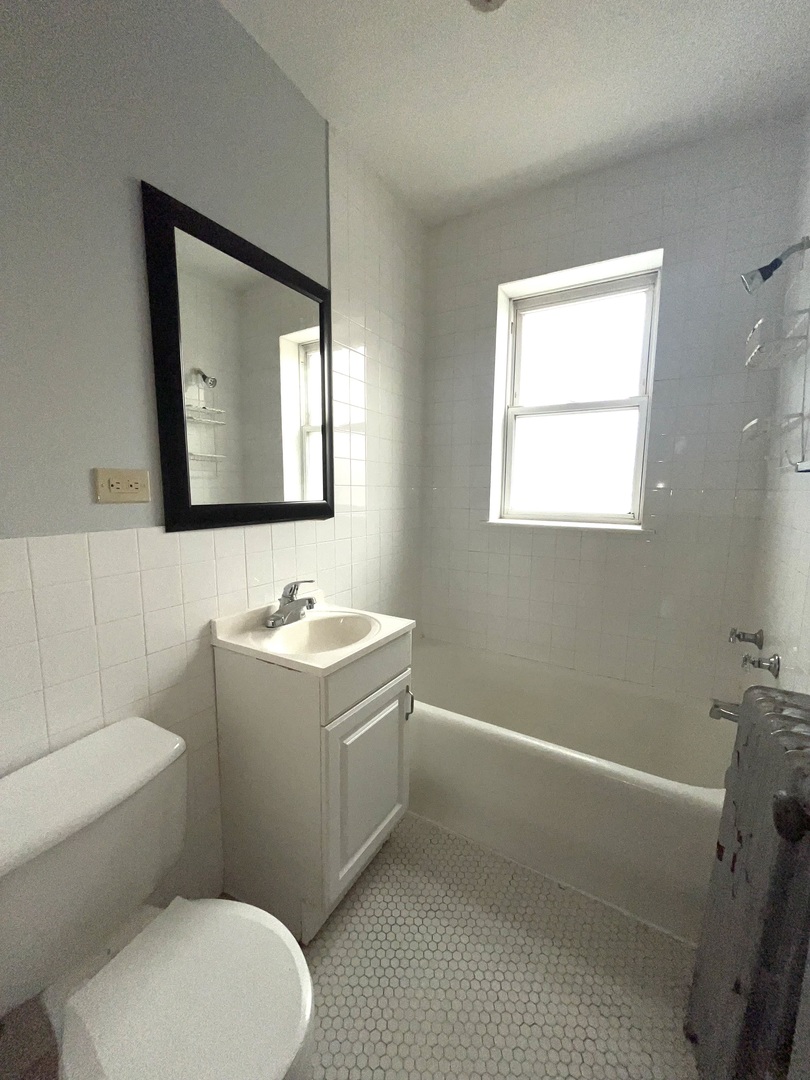 5852 West Higgins Avenue, Unit 3B Chicago, IL 60630 - Photo 8 of 9 a bathroom with a sink toilet and mirror