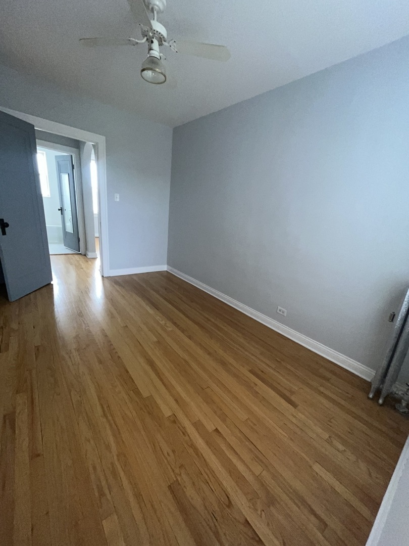 5852 West Higgins Avenue, Unit 3B Chicago, IL 60630 - Photo 9 of 9 a view of an empty room with wooden floor and a window