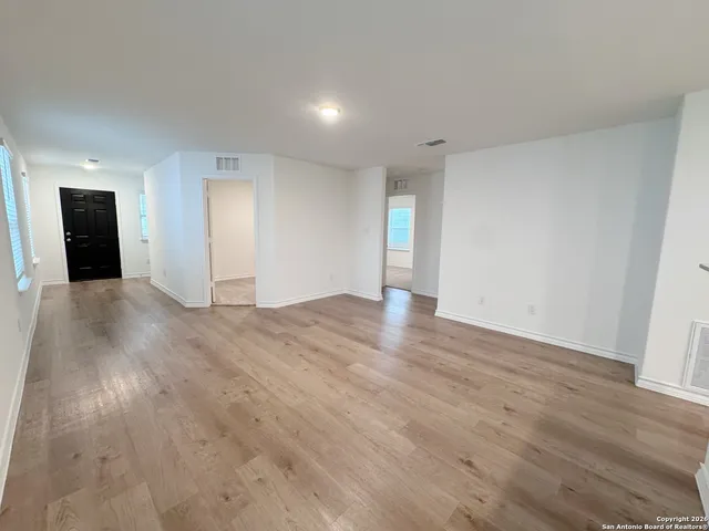 a view of an empty room with wooden floor