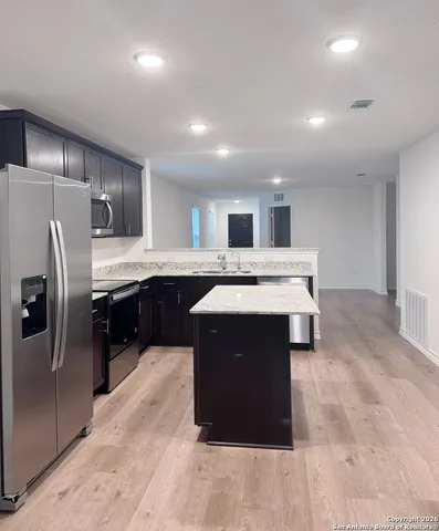 a kitchen with a sink refrigerator and cabinets