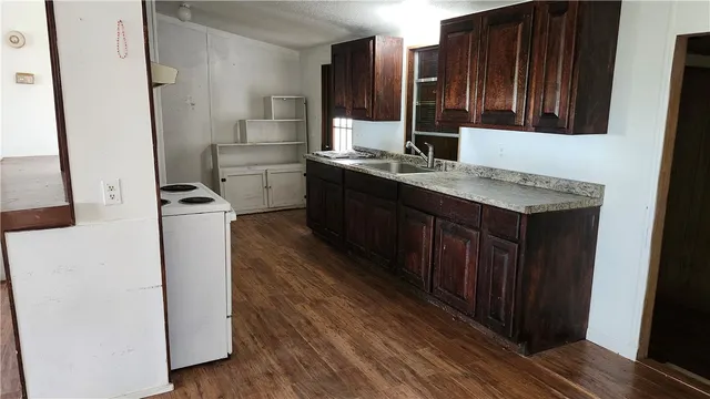 a kitchen with sink cabinets and wooden floor