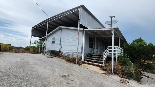 a view of a house with backyard and trees