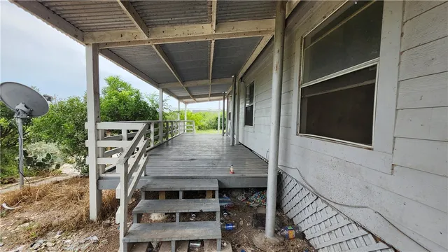 a view of a patio with table and chairs with wooden floor and fence