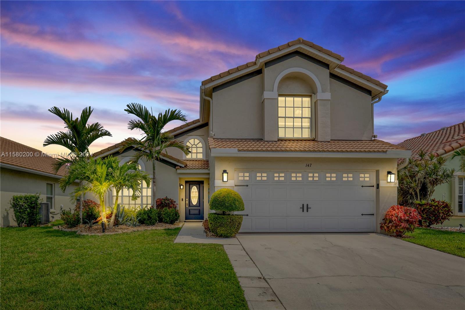 147 Stonebriar Boulevard Jupiter, FL 33458 - Photo 1 of 39 a front view of a house with a garden and entryway