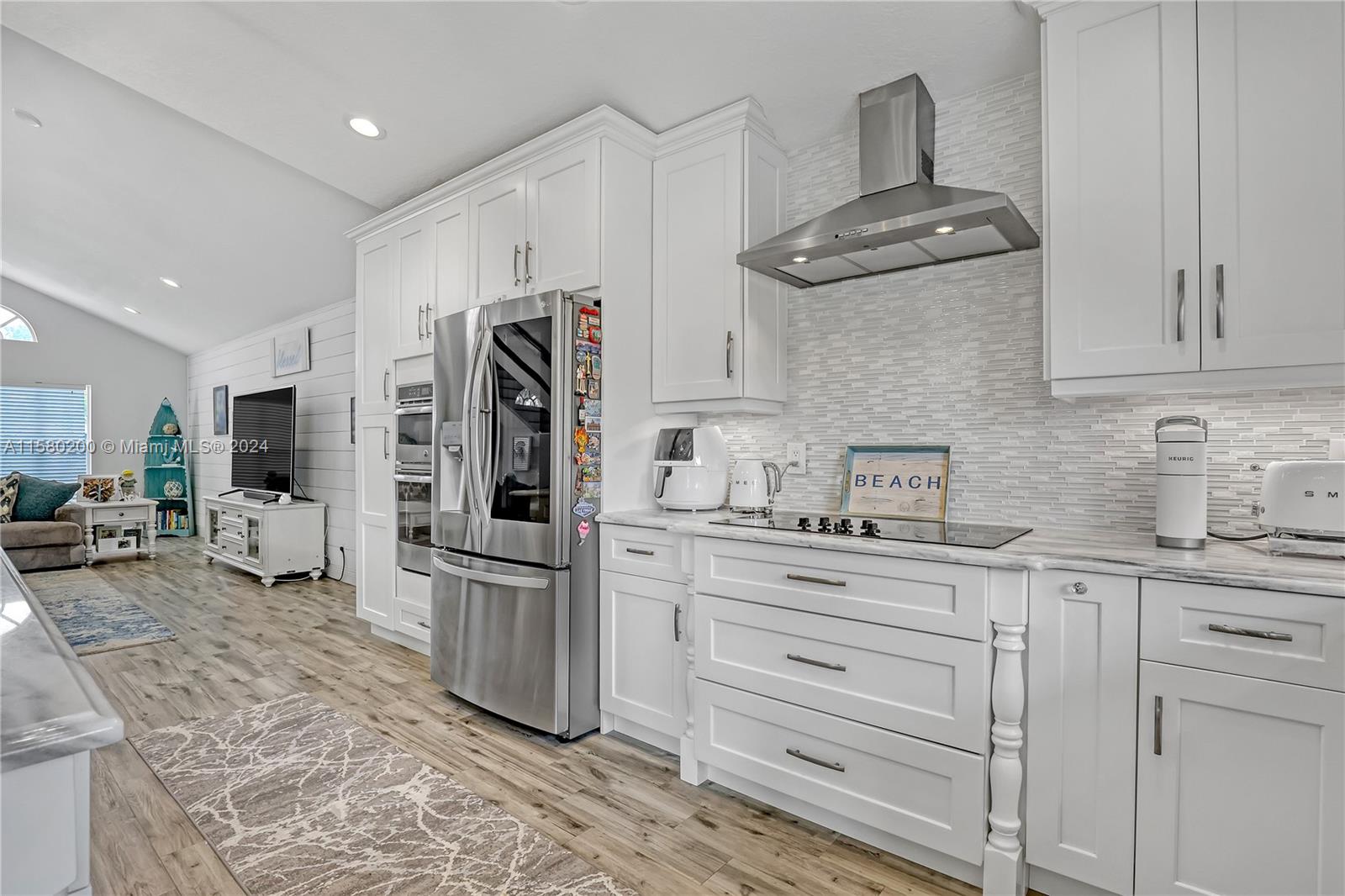 147 Stonebriar Boulevard Jupiter, FL 33458 - Photo 13 of 39 a kitchen with stainless steel appliances granite countertop a refrigerator a stove and a sink