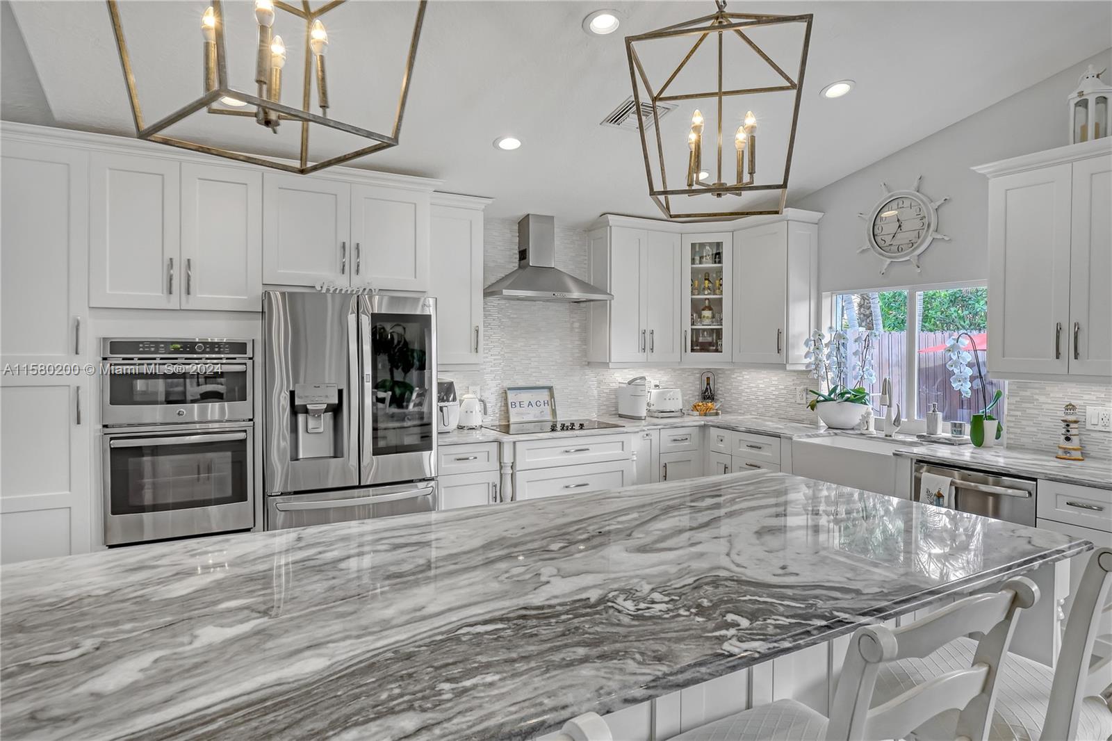 147 Stonebriar Boulevard Jupiter, FL 33458 - Photo 15 of 39 a large kitchen with stainless steel appliances granite countertop a sink window and cabinets