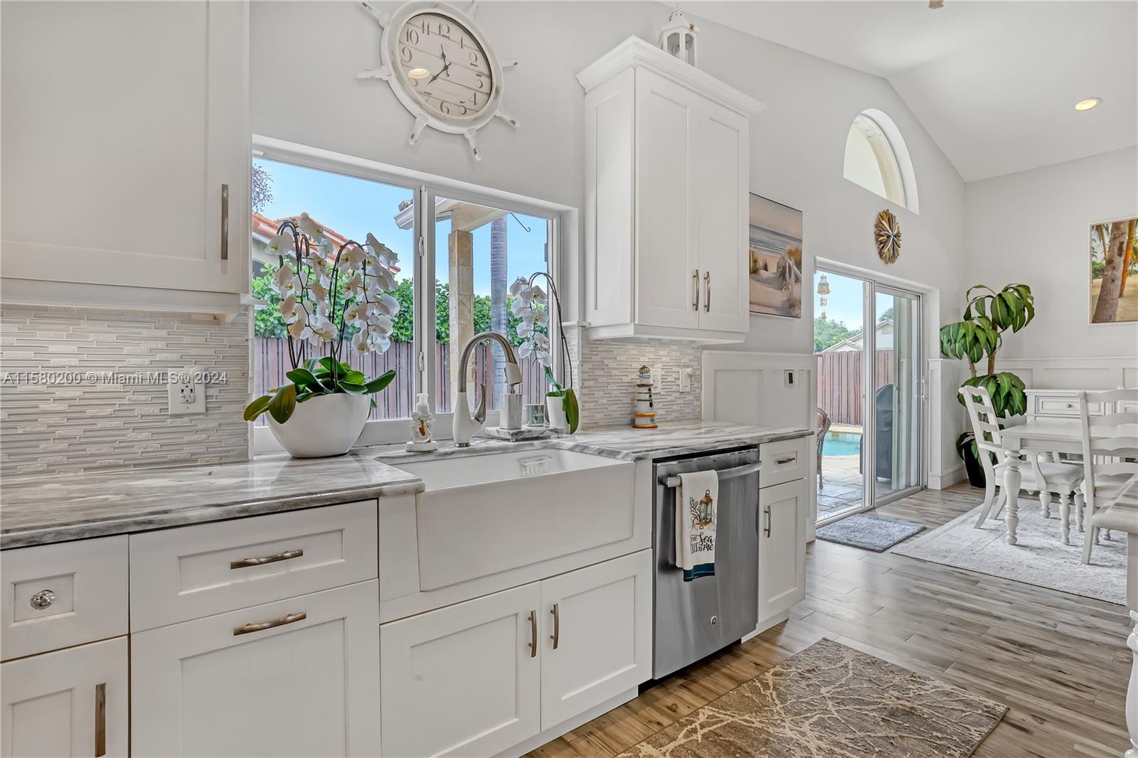 147 Stonebriar Boulevard Jupiter, FL 33458 - Photo 16 of 39 a kitchen with stainless steel appliances kitchen island granite countertop a table and chairs in it