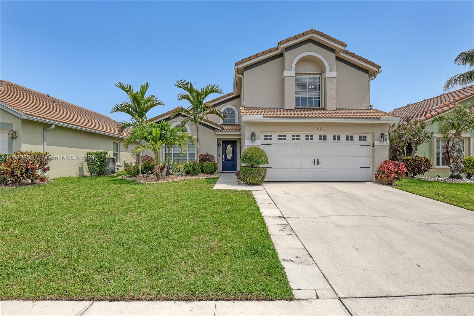 147 Stonebriar Boulevard Jupiter, FL 33458 - Photo 2 of 39 a view of house with garden and tall tress