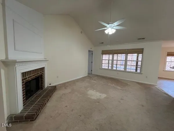 a view of an empty room with window and fireplace