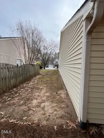 a view of backyard with wooden fence