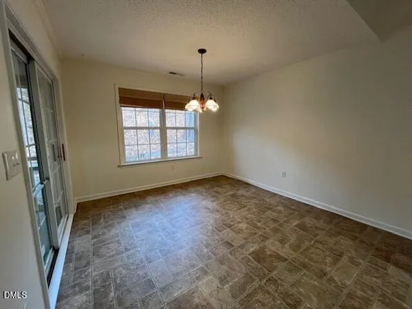 en empty room with windows and ceiling fan