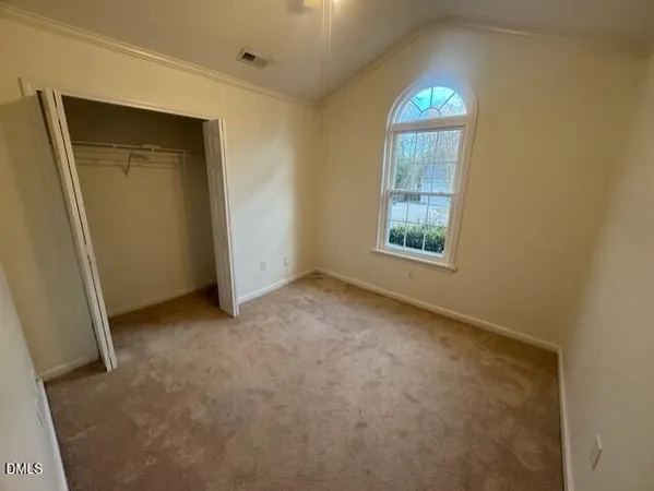 an empty room with windows and closet