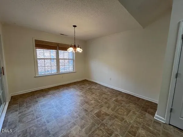an empty room with windows and chandelier fan
