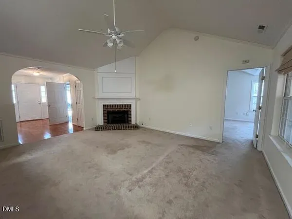 an empty room with fireplace and fan