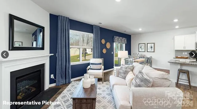 a living room with furniture a large window and a fireplace
