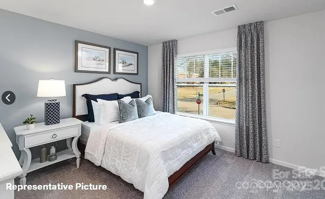 a bedroom with a bed and large window