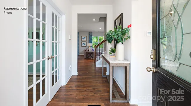 a view of a hallway with wooden floor and staircase
