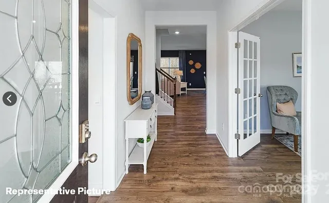 a view of a hallway with wooden floor and staircase