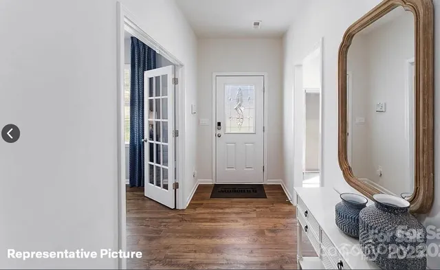 a view of a hallway with wooden floor and entryway