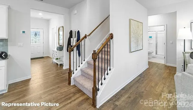 a view of a hallway with wooden floor and stairs
