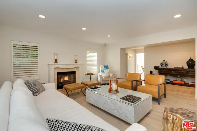 a living room with furniture a fireplace and a table