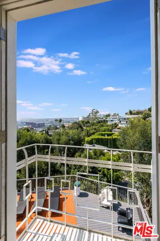 a view of a balcony with floor to ceiling windows with wooden floor