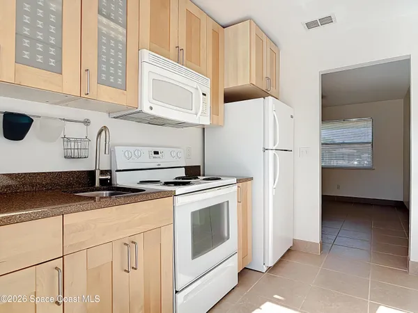 a kitchen with appliances a sink and cabinets