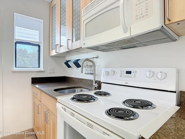 a kitchen with a stove a microwave and cabinets