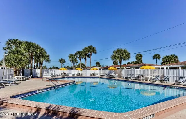 a swimming pool with outdoor seating yard and furniture