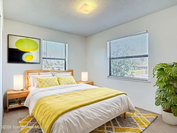a bedroom with a bed and painting on the wall