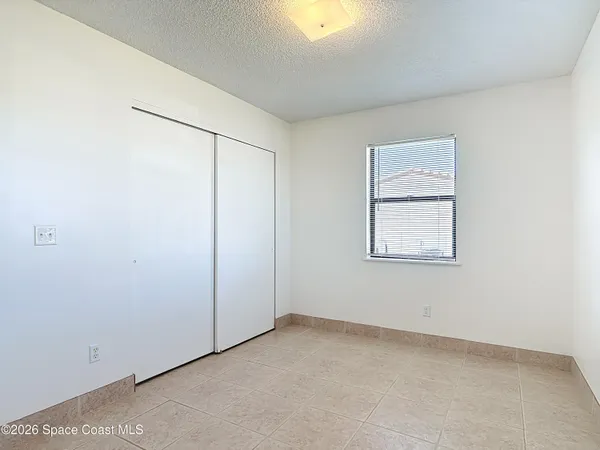 an empty room with windows and closet