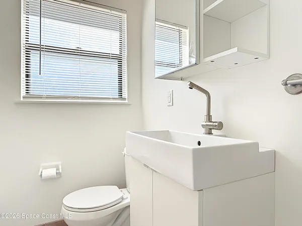 a bathroom with a sink a toilet and a window