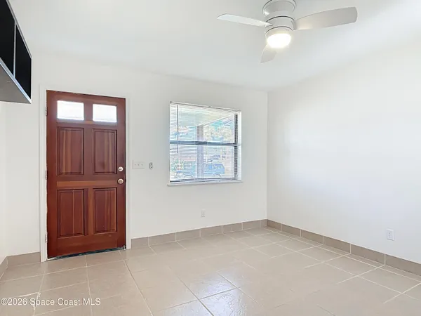 an empty room with windows and cabinet