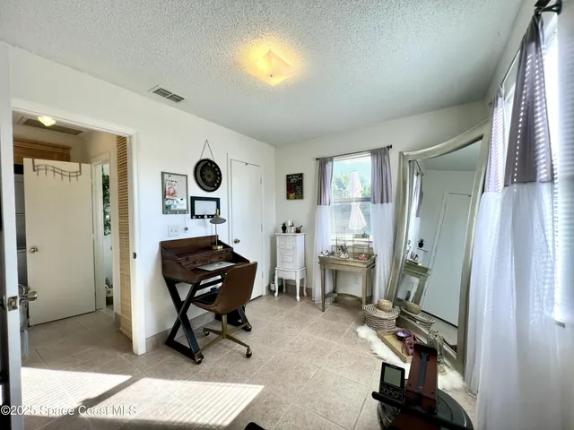 a view of a workspace with furniture and a window