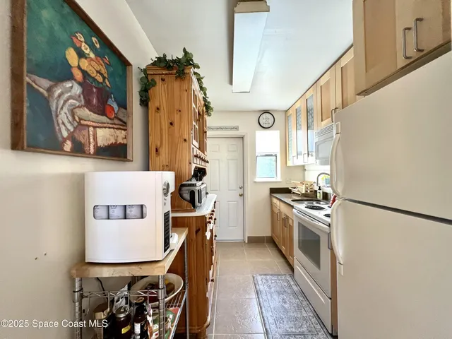 a kitchen with stainless steel appliances granite countertop a refrigerator a stove and a dining table with wooden floor