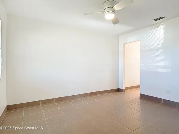 an empty room with a ceiling fan and a window