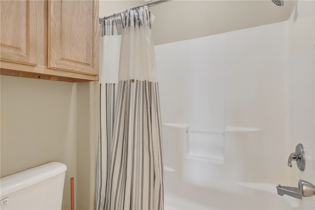 14427 Compass Street, Unit A6 Corpus Christi, TX 78418 - Photo 16 of 40 a bathroom with a shower curtain and toilet