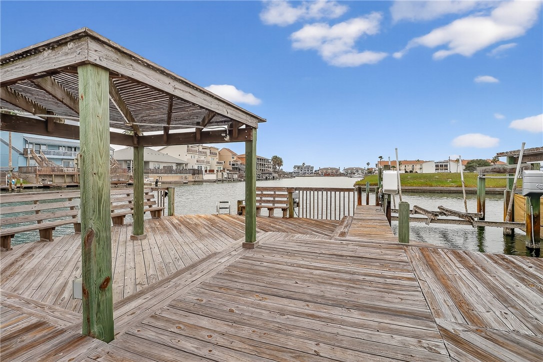 14427 Compass Street, Unit A6 Corpus Christi, TX 78418 - Photo 33 of 40 a view of a balcony with dining table and chairs with wooden floor