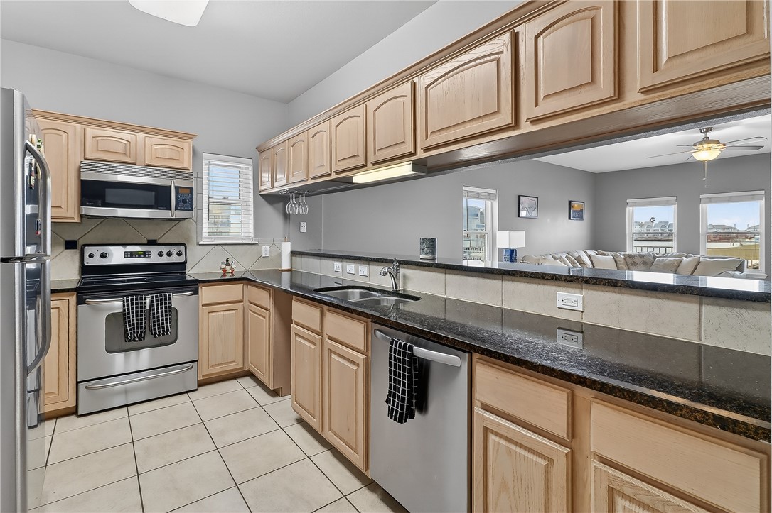 14427 Compass Street, Unit A6 Corpus Christi, TX 78418 - Photo 7 of 40 a kitchen with stainless steel appliances granite countertop a sink a stove top oven and granite counter tops