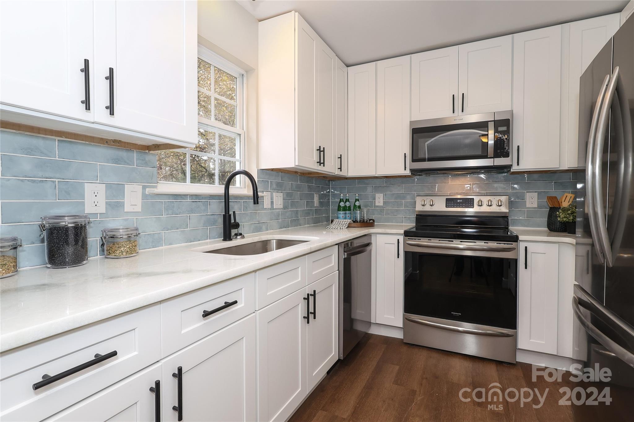437 Radio Road Charlotte, NC 28216 - Photo 12 of 30 a kitchen with stainless steel appliances granite countertop a sink a stove a microwave and cabinets