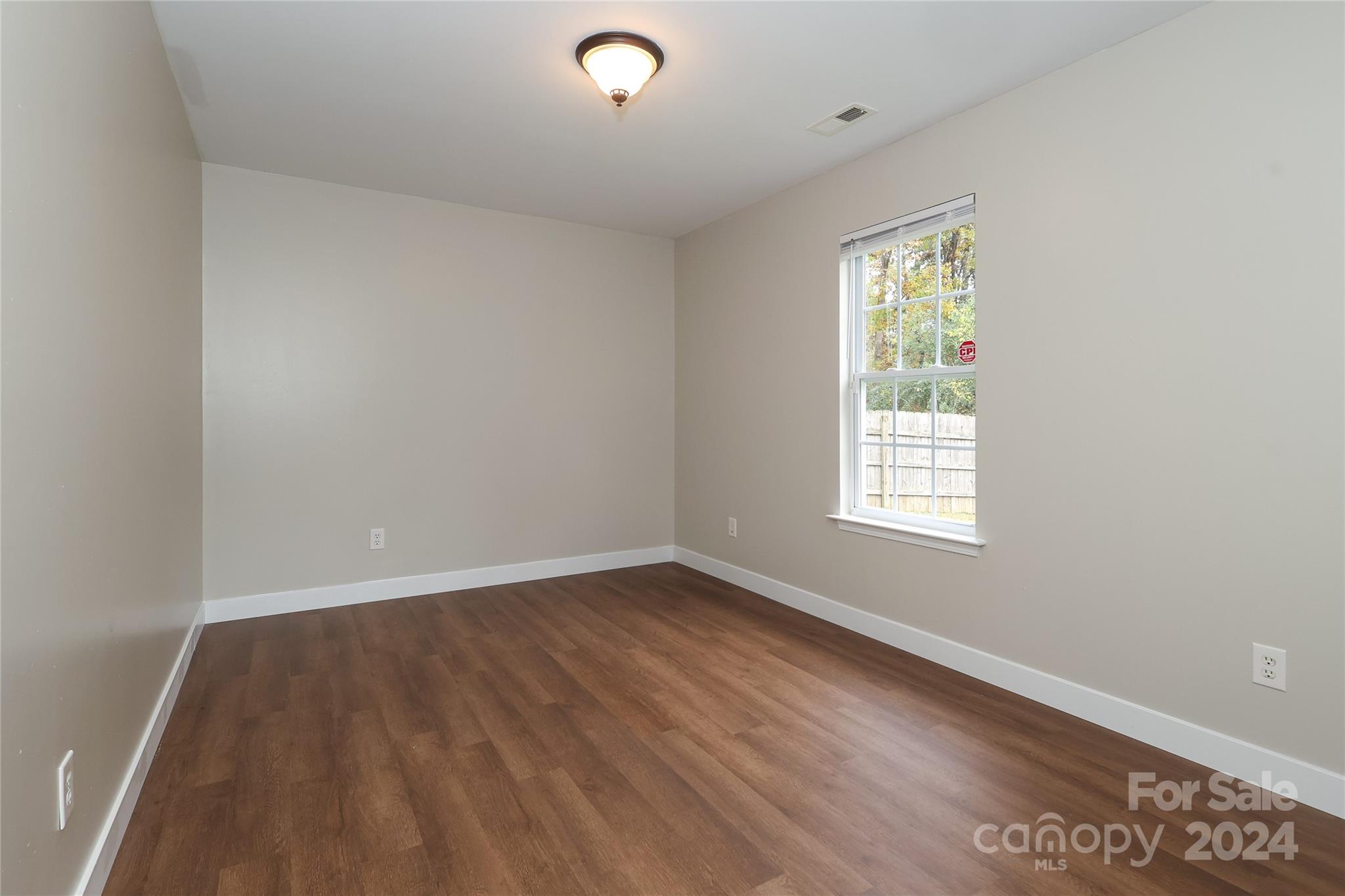 437 Radio Road Charlotte, NC 28216 - Photo 21 of 30 an empty room with wooden floor and windows