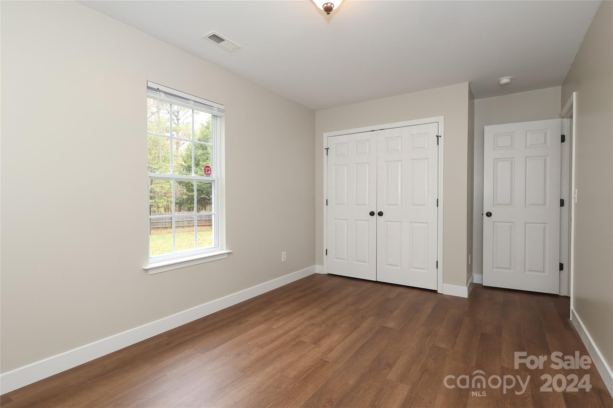 437 Radio Road Charlotte, NC 28216 - Photo 22 of 30 an empty room with wooden floor and windows