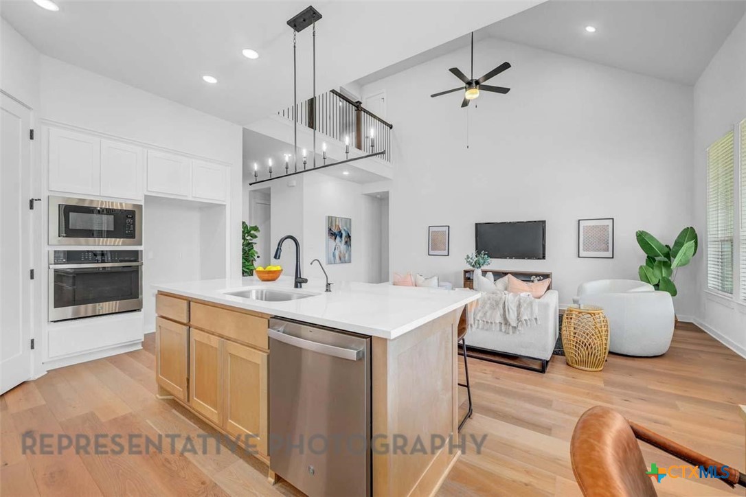 148 Spanish Oak Castroville, TX 78009 - Photo 3 of 20 a kitchen view with microwave a stove and white cabinets