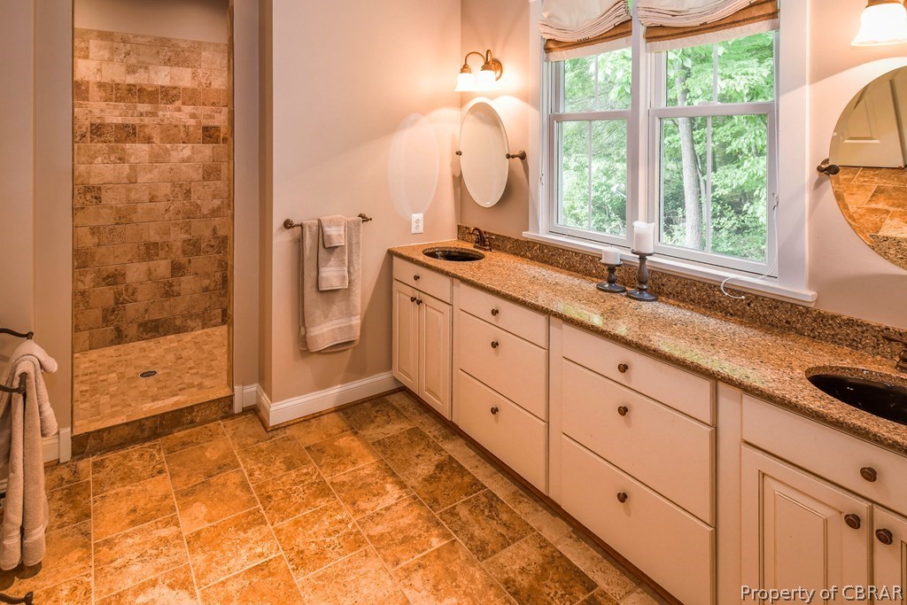 137 Mastons Wharf Road Lancaster, VA 22503 - Photo 17 of 39 a bathroom with a granite countertop sink mirror and a bathtub